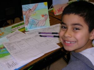 Picturing Writing boy with brainstorming sheet and painting in easel